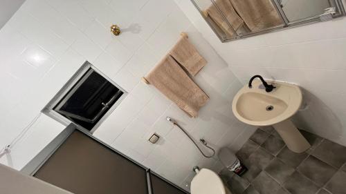 a white bathroom with a sink and a toilet at Conj Pajuçara 3 minutos da praia, 5 pessoas! in Maceió