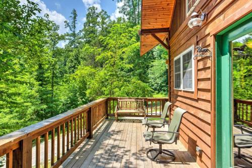 eine Hütte mit zwei Stühlen auf einer Holzterrasse in der Unterkunft Hot Tub & WiFi - ManeStay - Red River Gorge KY in Slade