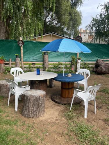 ein Tisch und Stühle mit einem blauen Sonnenschirm darauf in der Unterkunft Casa de Playa Mar de Ajo Castelli 1257 Beach House in Mar de Ajó
