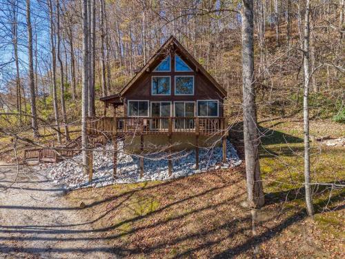 eine Blockhütte im Wald mit einer Feldstraße in der Unterkunft Hot Tub WiFi Pet-Friendly - Mountain Spirit in Slade