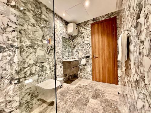 カサブランカにあるCozy, Elegant Apartment, Parking and Fiberのトイレとガラスのシャワー付きのバスルーム