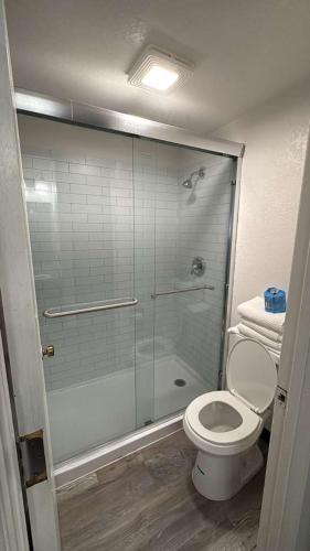 a bathroom with a toilet and a glass shower at Heritage Inn in Bellingham