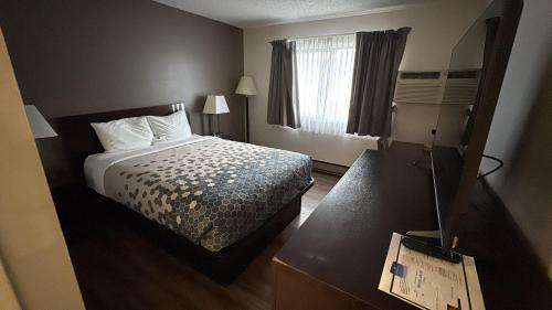 a hotel room with a bed and a window at Heritage Inn in Bellingham