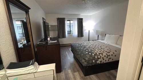 a hotel room with a bed and a mirror at Heritage Inn in Bellingham