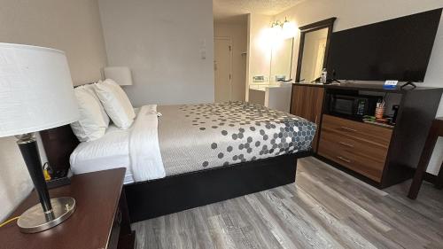 a hotel room with a bed and a flat screen tv at Heritage Inn in Bellingham