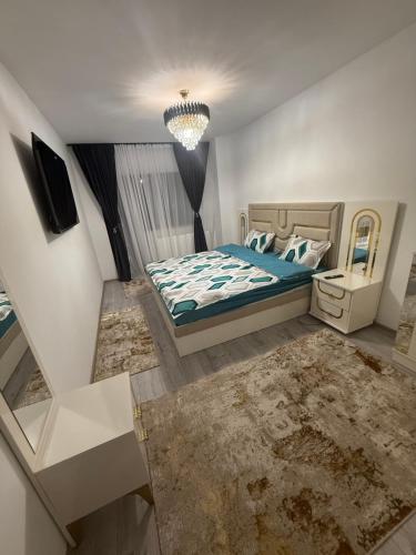 a bedroom with a bed and a chandelier at Apartament Promenada Luxury in Craiova