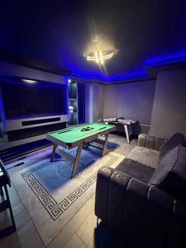 a living room with a ping pong table and a couch at SK Stays Modern Luxury Home With Jacuzzi Bath & Cinema Room in Shipley