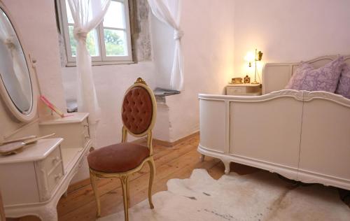 a bedroom with a chair and a bed and a mirror at FeWo Zar Ferdinand Schloss Weitersroda in Hildburghausen