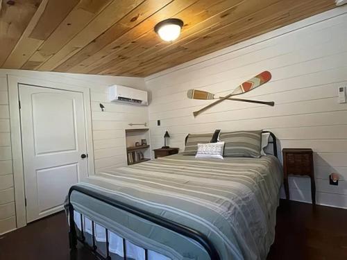 ein Schlafzimmer mit einem Bett mit Holzdecke in der Unterkunft Cameron's Cottage at The Lake in Tallassee
