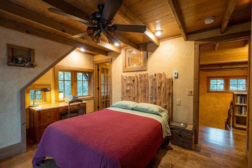 een slaapkamer met een bed en een plafondventilator bij Anam Cara Cabin in Mohawk