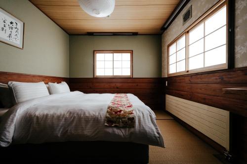 une chambre avec un lit et deux fenêtres dans l'établissement Raicho Lodge Madarao, à Iiyama