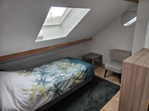 a bedroom with a bed and a window and a chair at Maison Sérénité in Lailly-en-Val