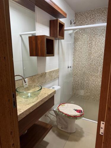 Un baño con lavabo, inodoro y ducha. en Casa 2 dormitórios, en Passo de Torres