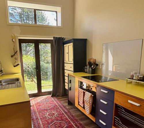a kitchen with a sink and a counter top at Pauanui Orchard Farmstay - Pet Friendly! in Hikuai