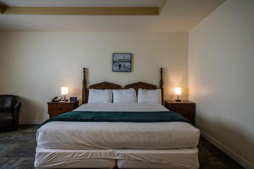 a bedroom with a large bed with two night stands at Sleep Suite Motel in Steinbach