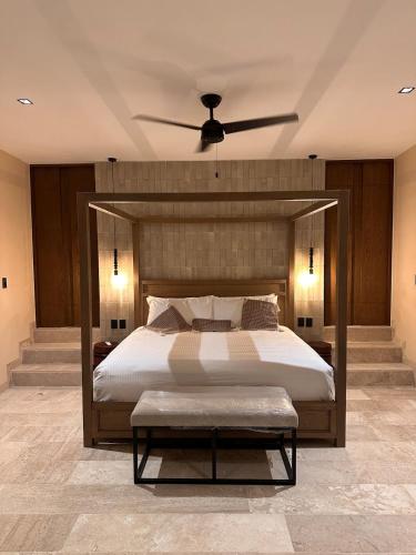 a bedroom with a large bed with a ceiling fan at Casa Chultun Mérida Centro in Mérida