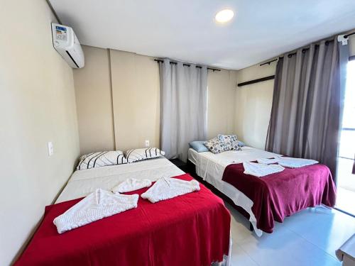 two beds sitting next to each other in a room at Liszen flats in Porto De Galinhas