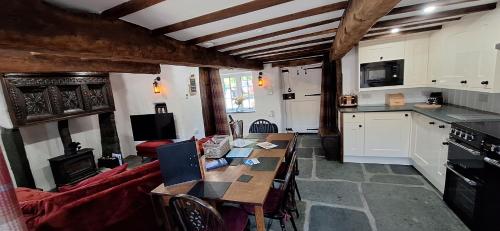 a kitchen and living room with a table and a couch at 2 Double Bed Cottage Hottub Lake District Keswick in Keswick