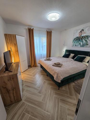 a bedroom with a large bed and a wooden floor at House4Seasons in Lič