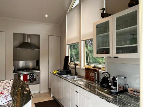 a kitchen with white cabinets and a counter top at Dreamtime Bay 