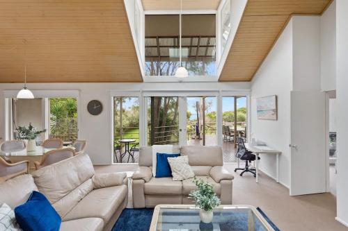 ein Wohnzimmer mit Sofa und Tisch in der Unterkunft Private Access to Beach Oceanview with Home Gym in Cowes