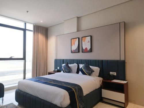 a bedroom with a large bed and a large window at فندق جراند جرين in Jazan
