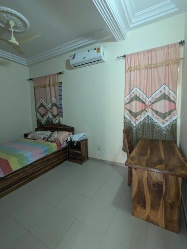 Un dormitorio con dos camas y un banco en él. en Villa Ange Coeur, en Komé