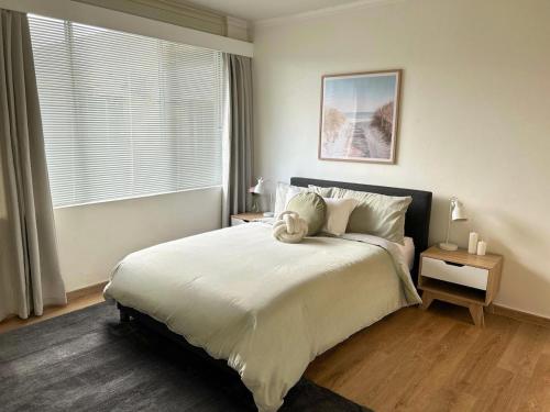 a bedroom with a large bed and a window at Renovated Cosy Stay Near CBD & StKilda with Pool & Sauna in Melbourne
