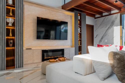 Una sala de estar con un sofá blanco y una chimenea. en Luxury Oasis Porto de Galinhas, en Ipojuca