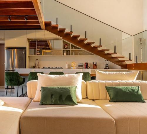 un gran sofá en una sala de estar con una escalera en Luxury Oasis Porto de Galinhas, en Ipojuca