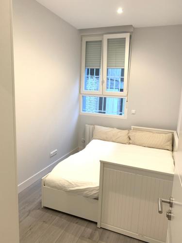 a small bedroom with a bed and a window at Urban Suites Aluche in Madrid