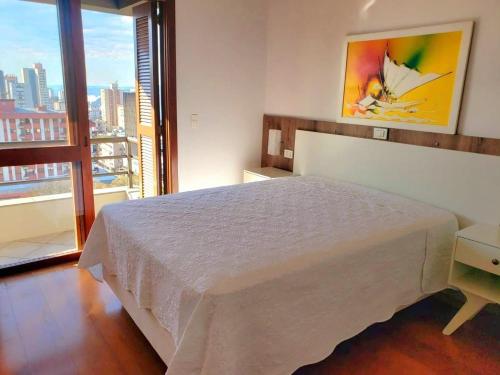 a bedroom with a bed and a large window at Apto Vista Incrivel 7 pess in Bento Gonçalves