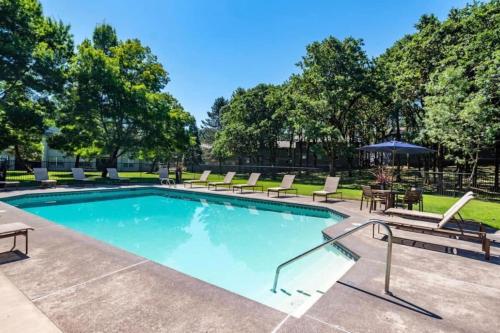 a swimming pool with lounge chairs and a table at The Study, a Summer Retreat in Corvallis