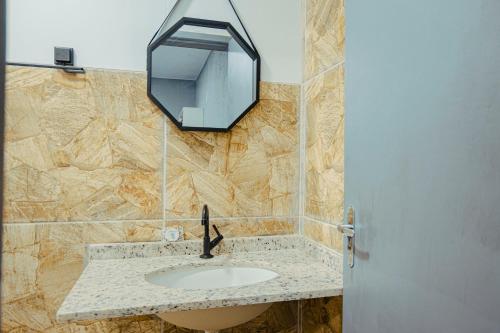 a bathroom with a sink and a mirror on the wall at Chalé por do Sol in Aracaju