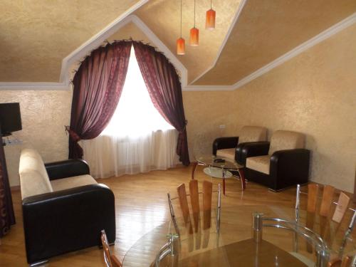 a living room with chairs and a glass table at Jermuk Villa Imperial in Jermuk
