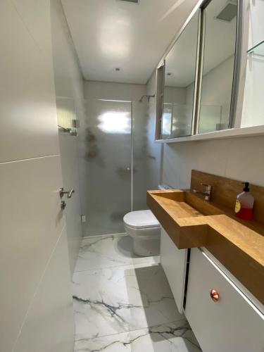 a bathroom with a toilet and a sink and mirror at Hostel Beija-Flor in Itajaí