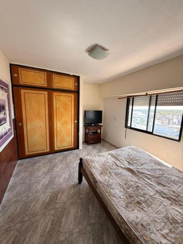 a bedroom with a bed and a television in it at San Jorge in San Clemente del Tuyú