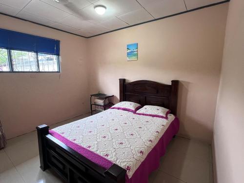 a bedroom with a large bed with purple sheets at Apartment near the Río Niño in Upala