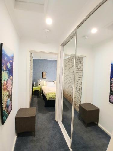 a bedroom with a bed and a mirror at Marazul BEST DEAL - Stone Bathtub, WIFI, Functional - Mandarins and lemons when available in Vincentia