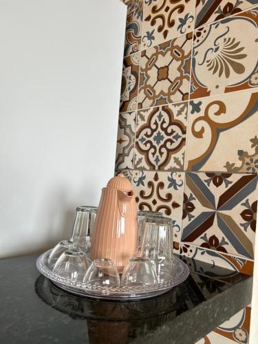 a table with two glasses and a vase on it at Espaço completo com garagem, estrutura e móveis novos! in Rondonópolis