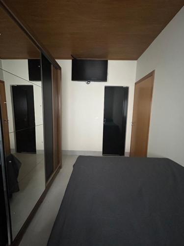 a room with two doors and a bed in it at Espaço completo com garagem, estrutura e móveis novos! in Rondonópolis