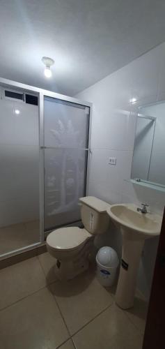 a bathroom with a toilet and a sink and a shower at Macas Comfort Apartment in Macas