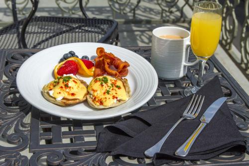a plate of breakfast food on a table with orange juice at Bourbon Orleans Hotel in New Orleans