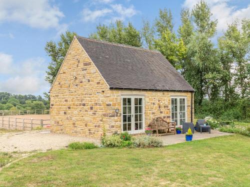 a small brick building with a patio in a yard at Little Barn in Shirland