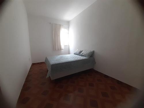 a small bedroom with a bed and a window at Suite Umarizal cop30 in Belém