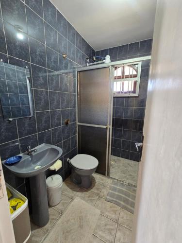 a bathroom with a toilet and a sink and a shower at Casa em Shangri-la próxima ao mar in Pontal do Paraná