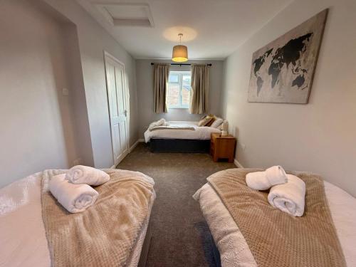a bedroom with two beds with towels on them at Squires House Long Stays Sleep 10 Free Parking 