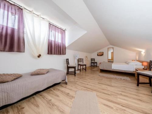 a bedroom with two beds and a table and chairs at Apartments Scerbe Gordana & Miljenko Rab - One Bedroom Apartment with Terrace 3 in Otok Rab