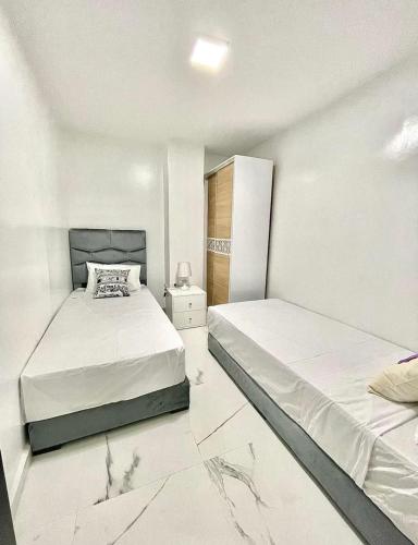a bedroom with two beds and a night stand at Seaside 1 min From Beach & Train Station in Tangier