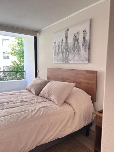 a bedroom with a bed with a picture on the wall at Keep walking in Nuñoa in Santiago